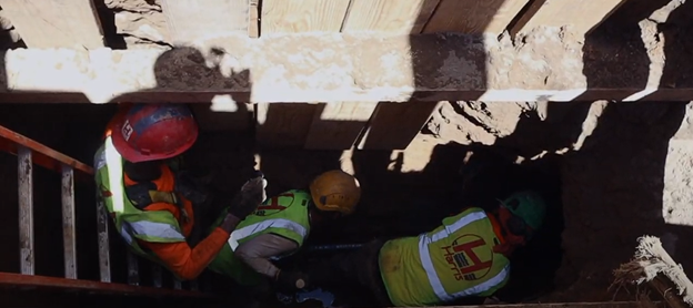 Three employees working in sewer trench with shoring